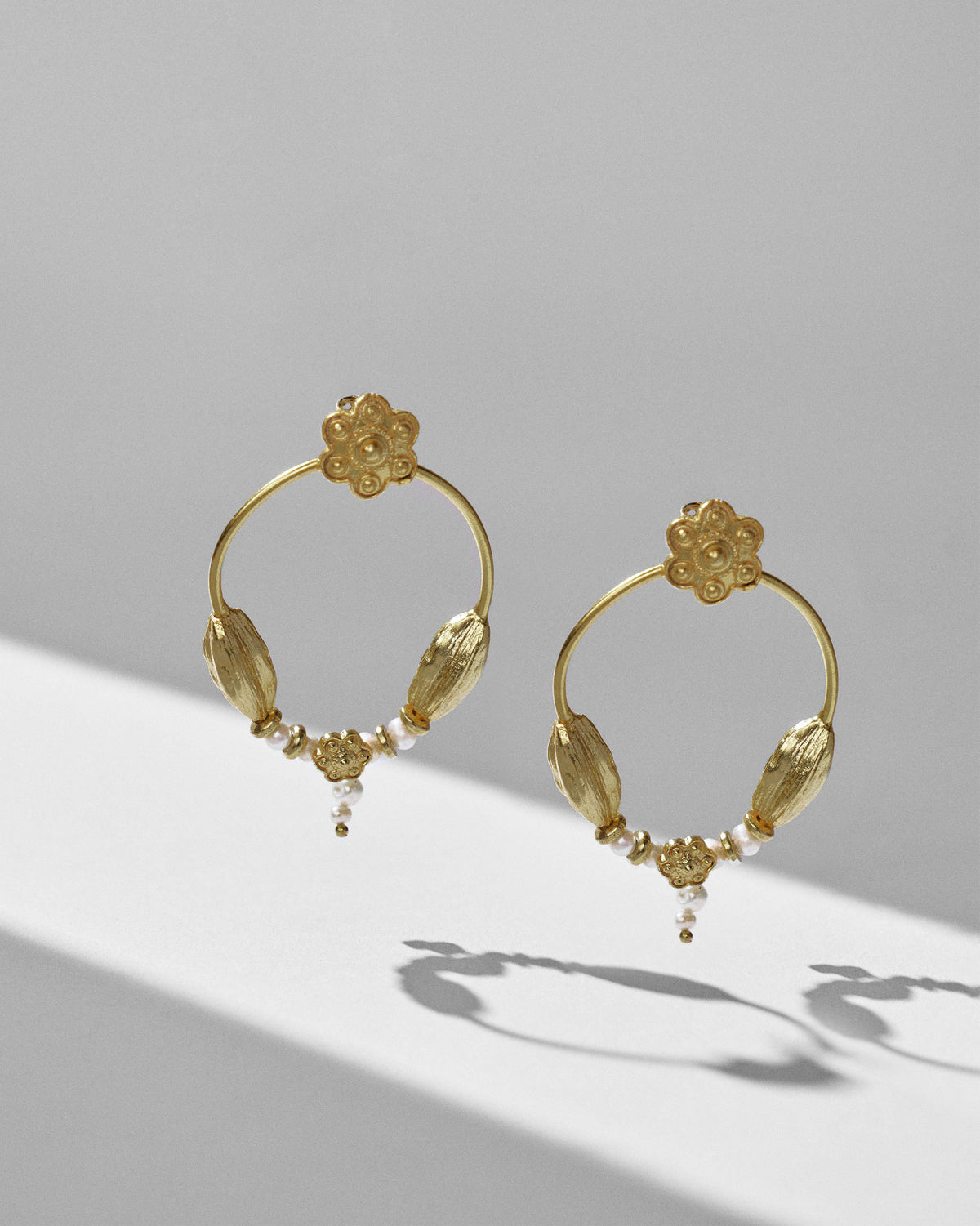 Gold Kumud hoops showing cardamom-like pods, flowers and pearl drops.