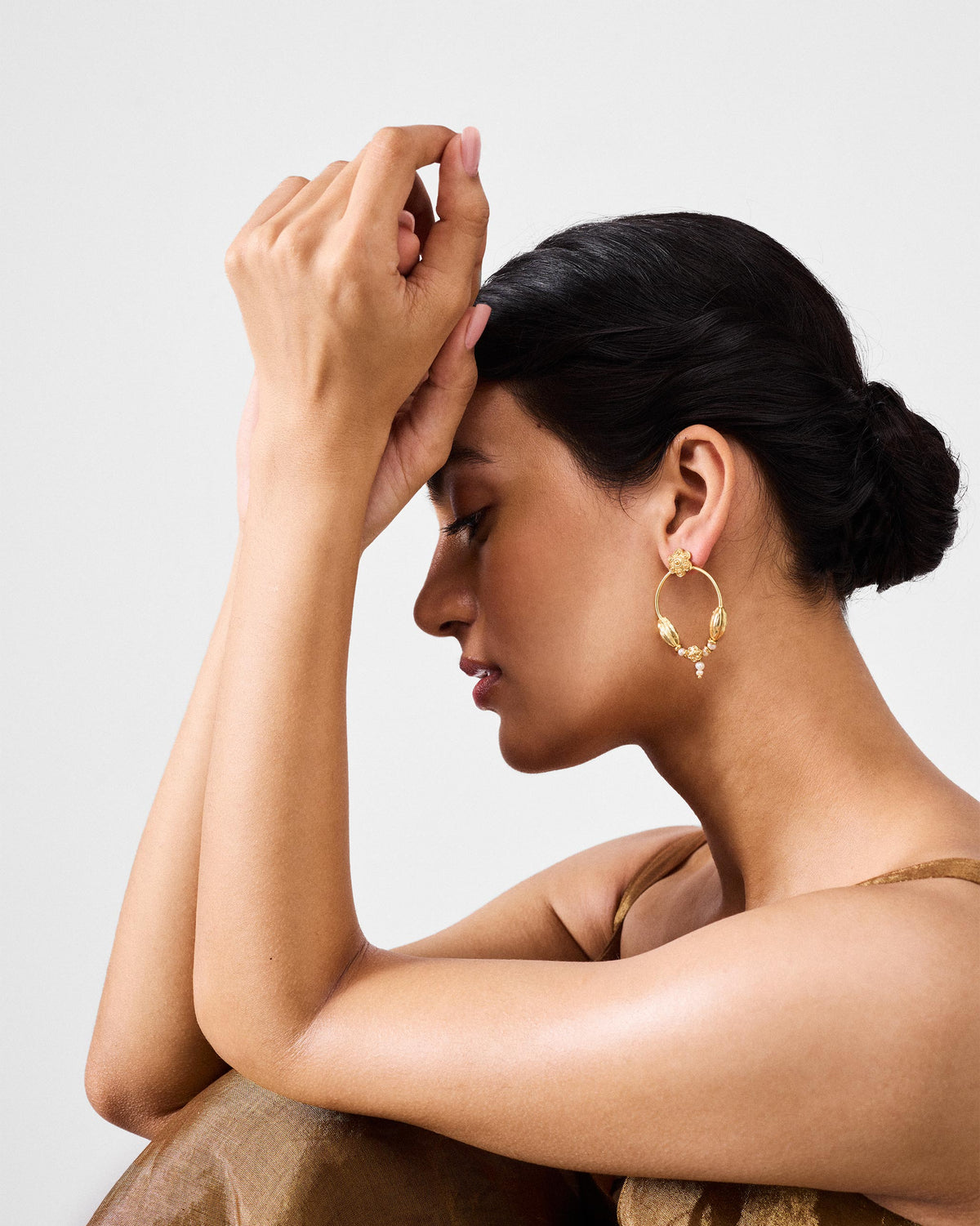 Side profile of a gold Kumud hoop with pod accents and a pearl drop.