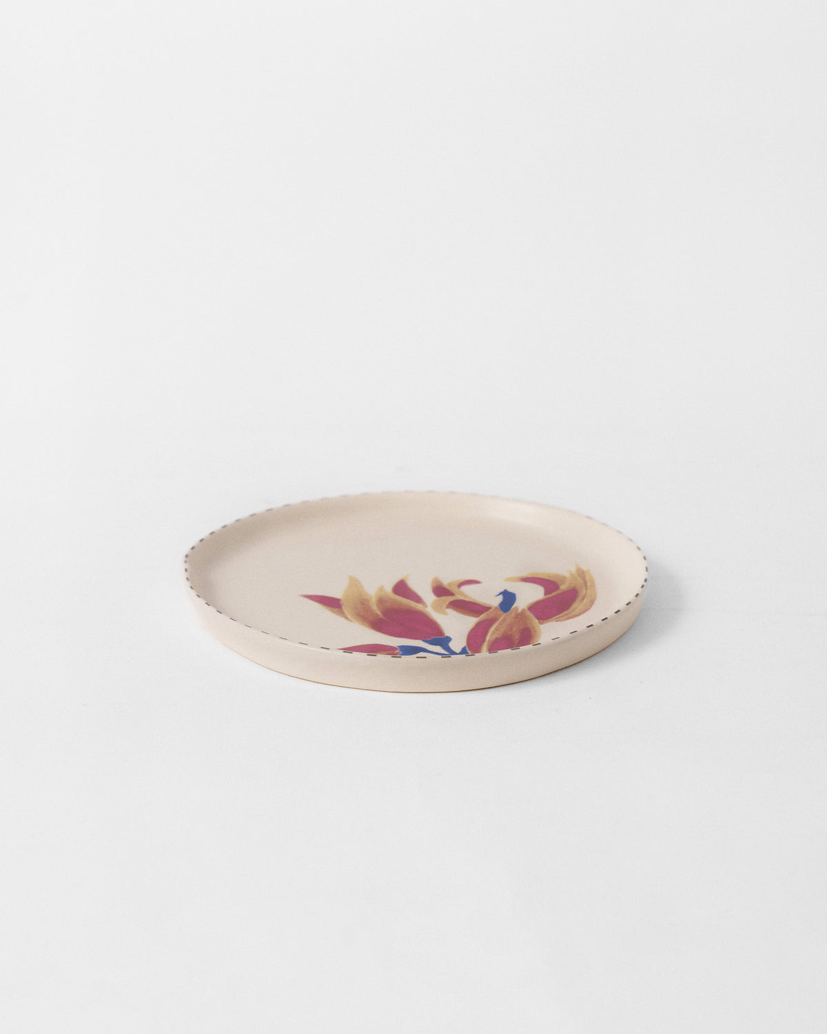 Ivory Palash dessert plate with magenta and ochre flowers and a dotted rim.