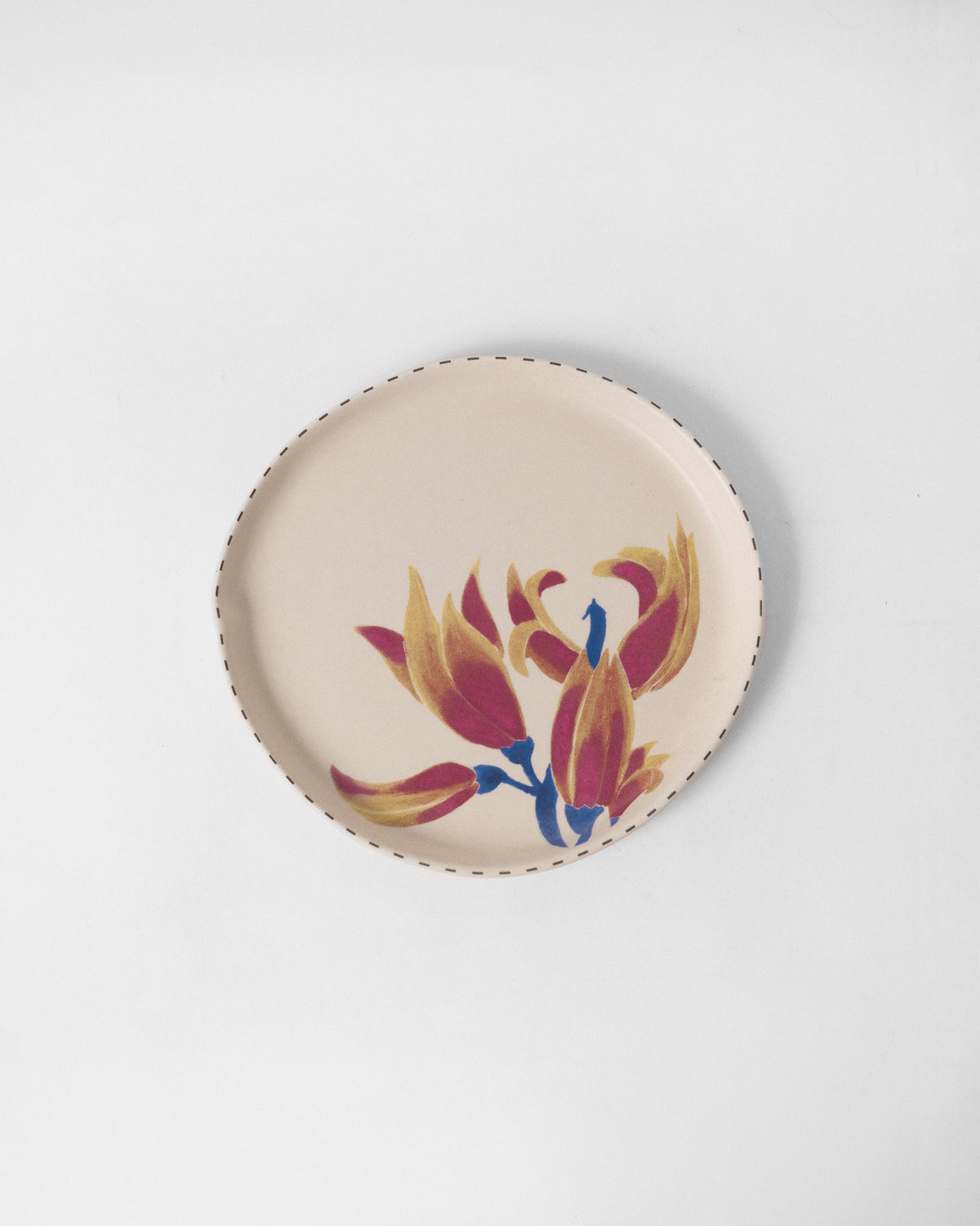 Overhead view of an ivory Palash dessert plate with magenta and ochre blossoms.