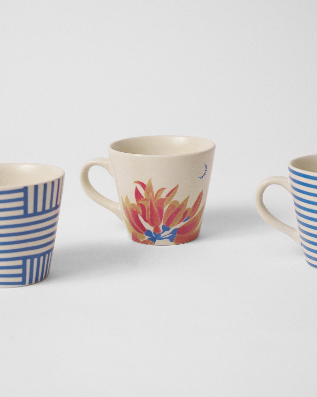 Close-up of a Koel espresso mug showing an orange palash flower motif.
