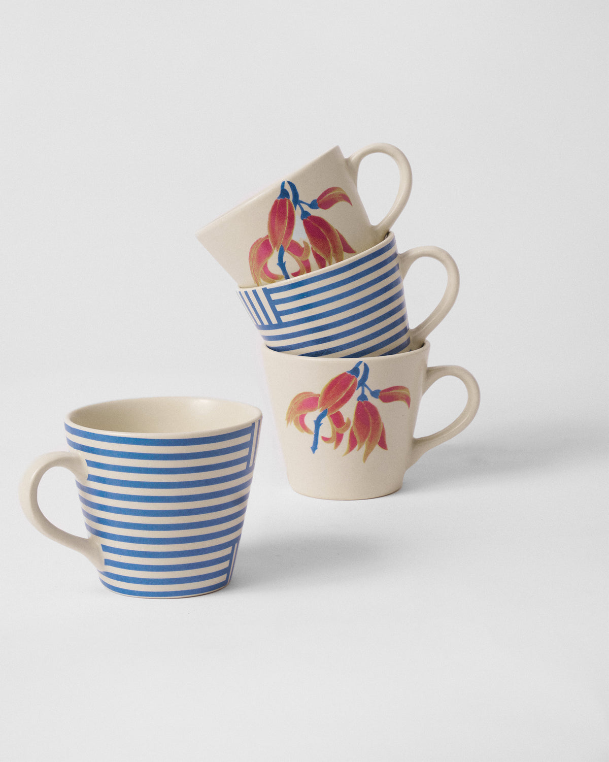 Set of four Koel espresso mugs with blue stripes and orange palash blooms.