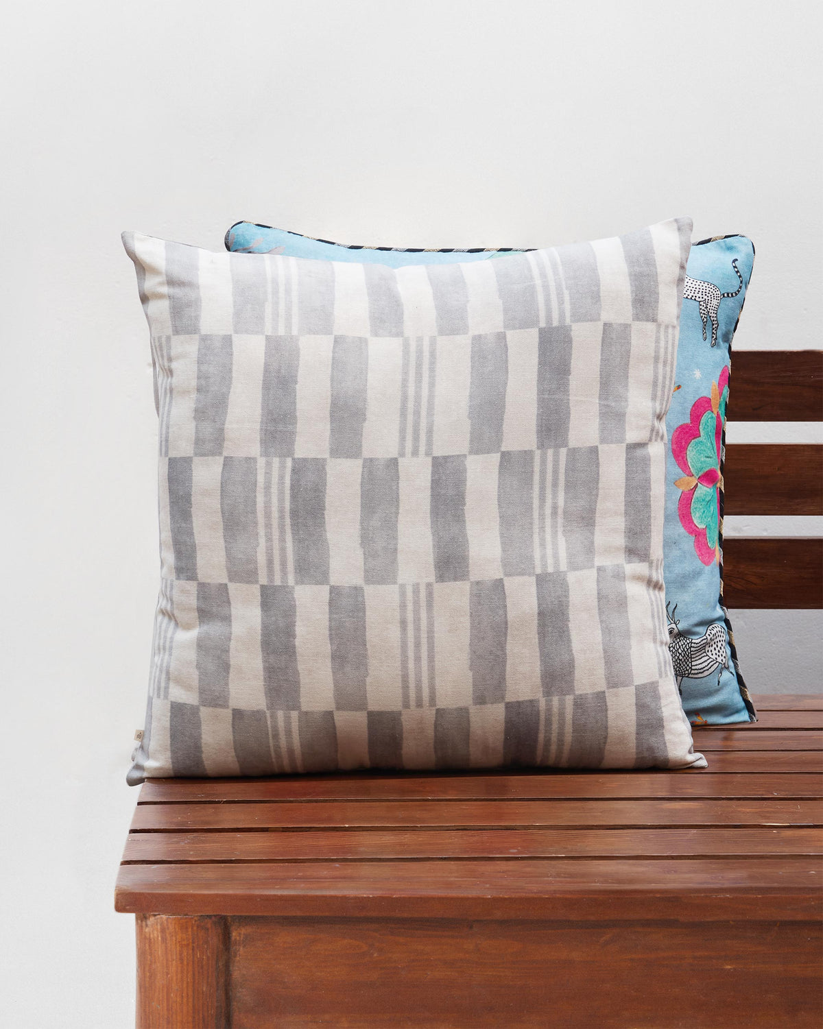 Cushion cover with a grey and cream block pattern.