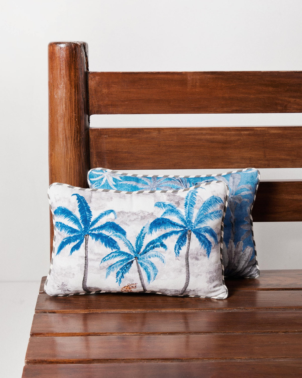 Sindhu car cushion with a white base and blue palm trees.