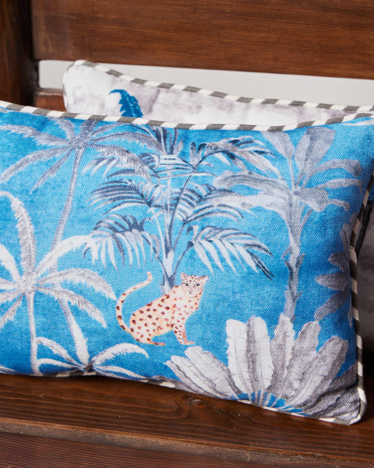 Close-up of a Sindhu car cushion showing palm trees and a leopard.