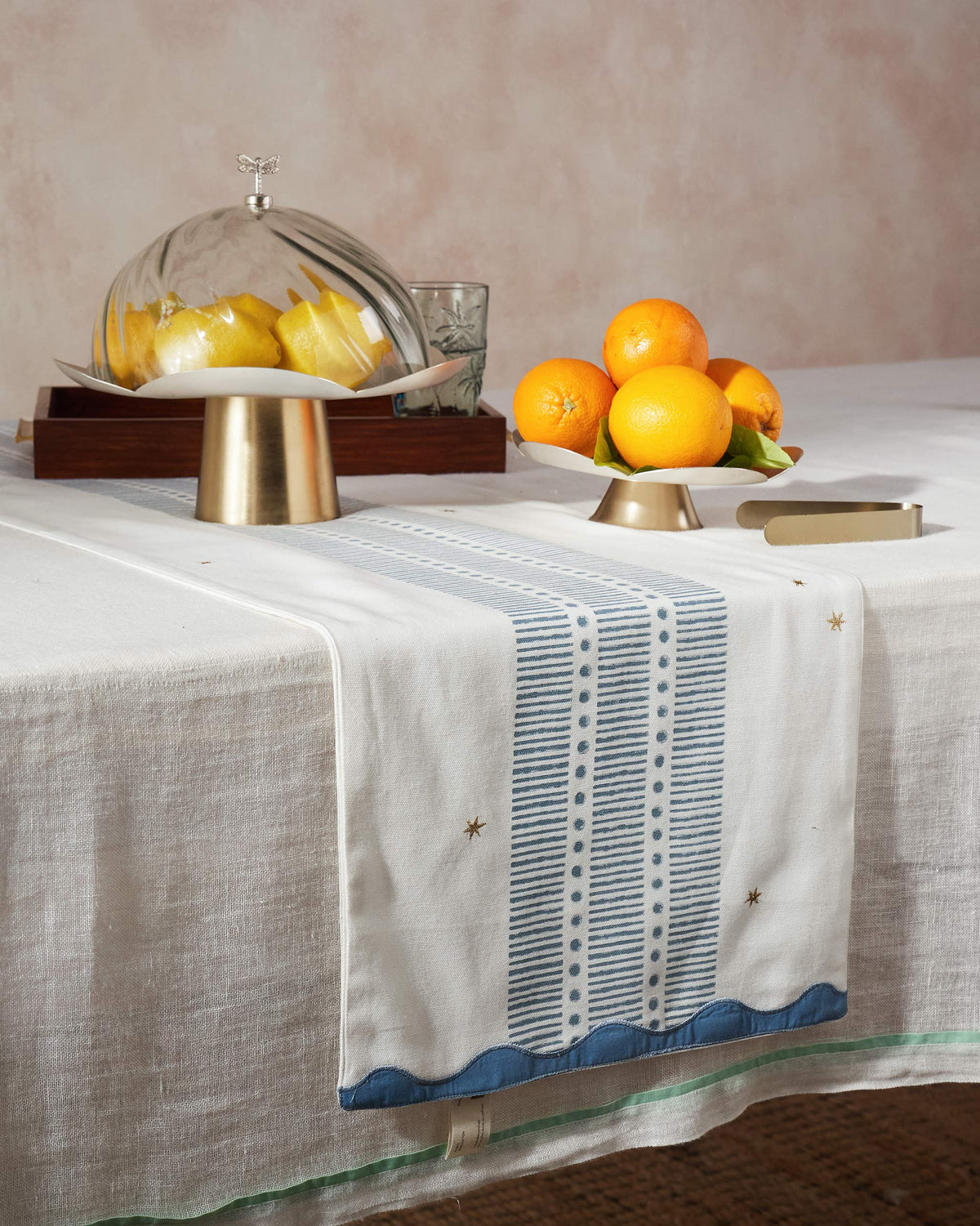 Ambi table runner with blue stripe band and gold stars on a dining table.