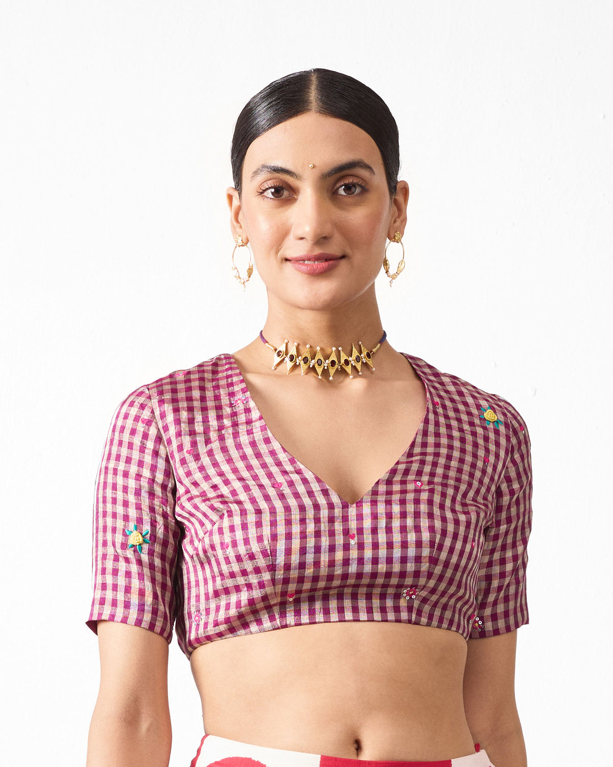 Person wearing a magenta gingham Dori Blouse with small embroidered motifs.