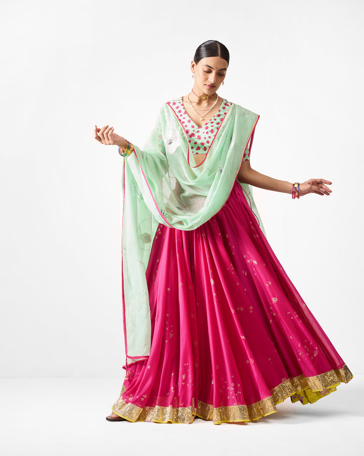 Sea blue Fiza Dupatta with pink border draped across a pink lehenga.