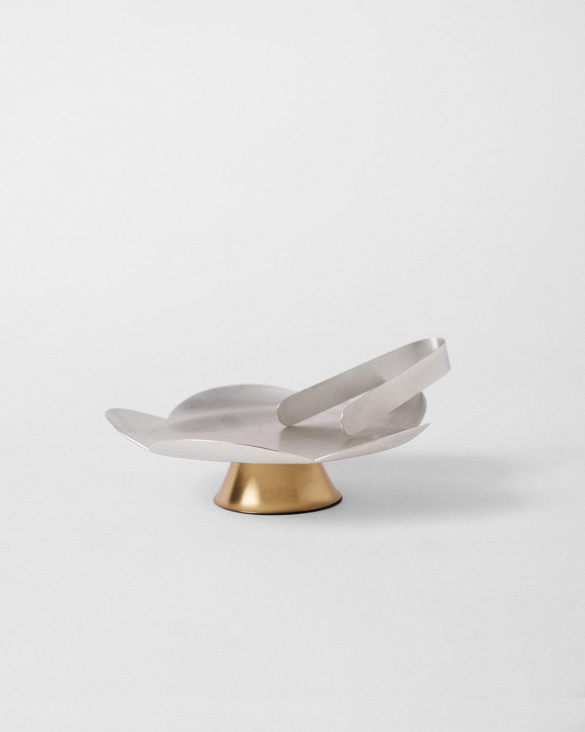 Almond Blossom Platter With Tong on a gold footed base, with the tong resting on top.