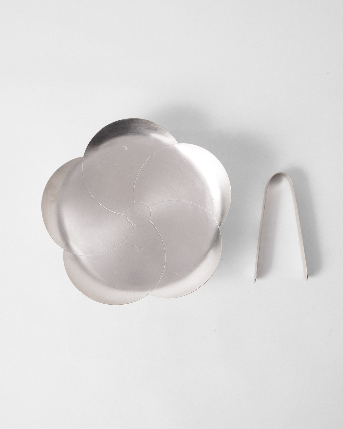 Almond Blossom Platter With Tong laid flat, with its petal-shaped edge and tong beside it.