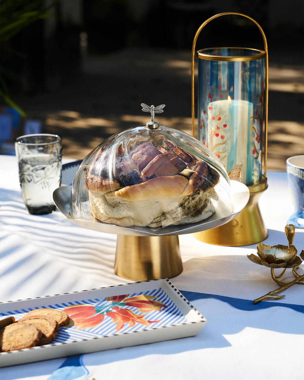 Almond Blossom Cloche covering bread on a brass pedestal stand.