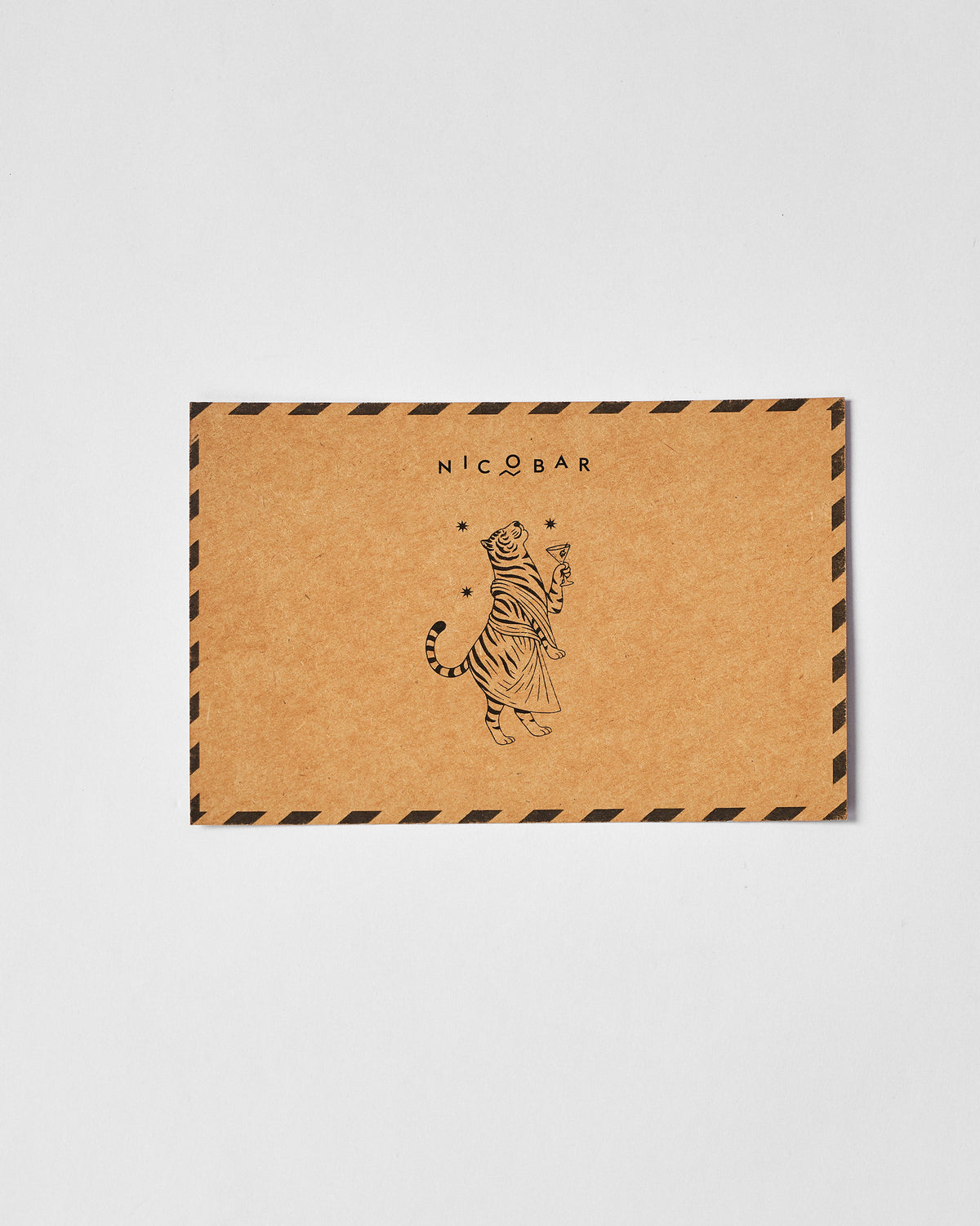 Kraft Nicobar card with a tiger holding a cocktail glass illustration.