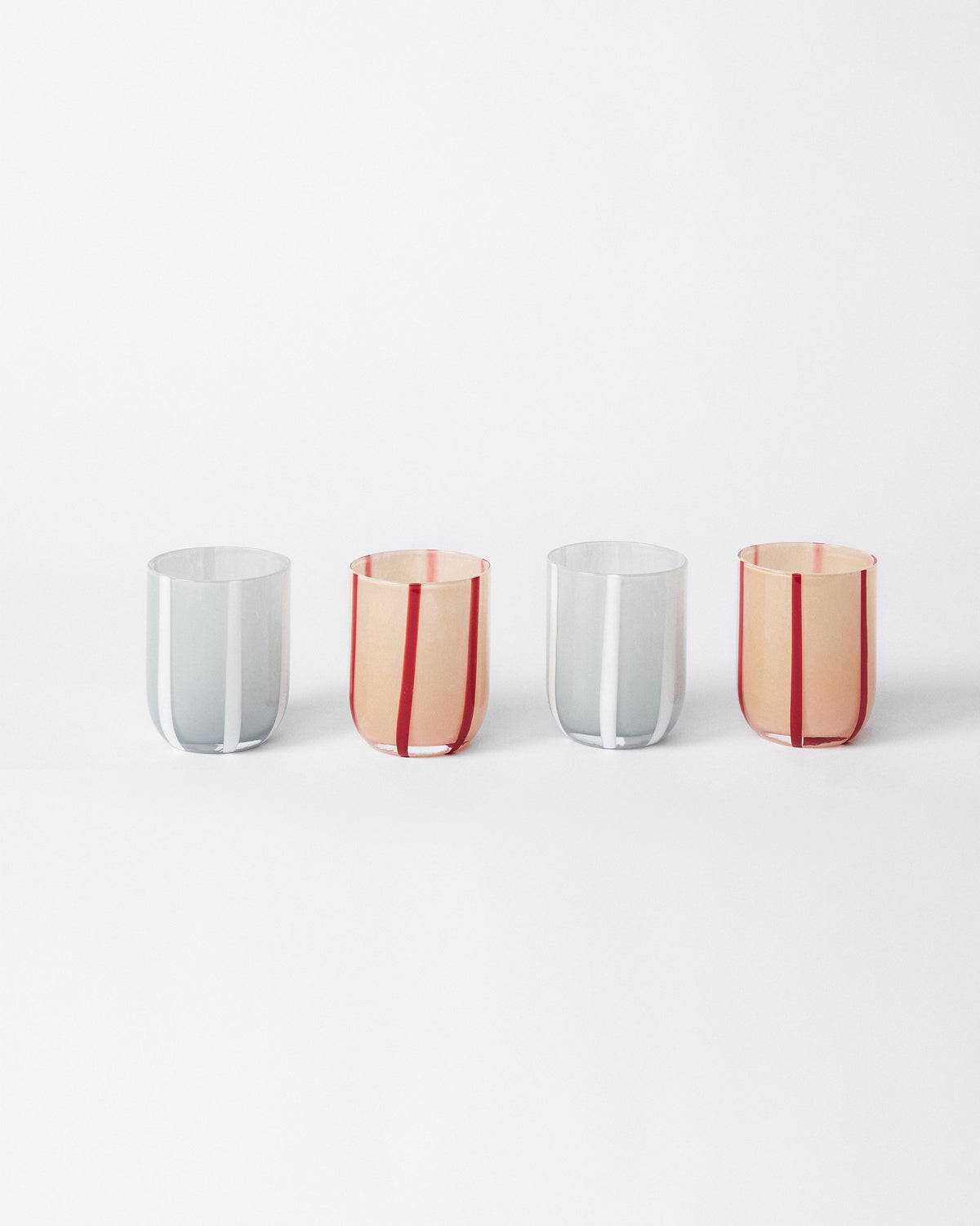 Set of four Demi tumblers with peach-red and grey-white stripes.