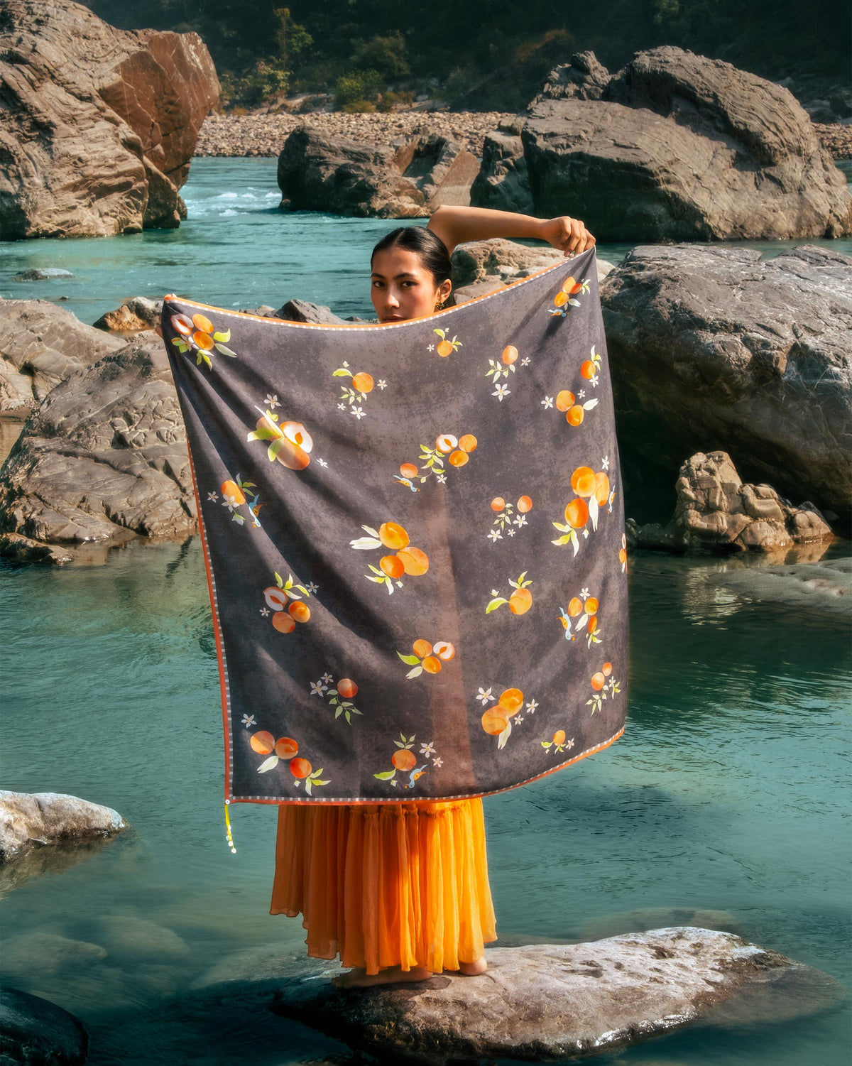 Charcoal Apricot Scarf with orange fruit print held open.