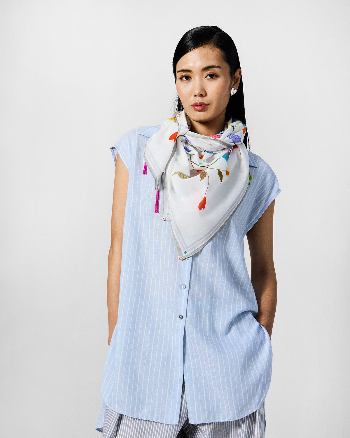 Person wearing the Jaal Scarf at the neck with tassels hanging.