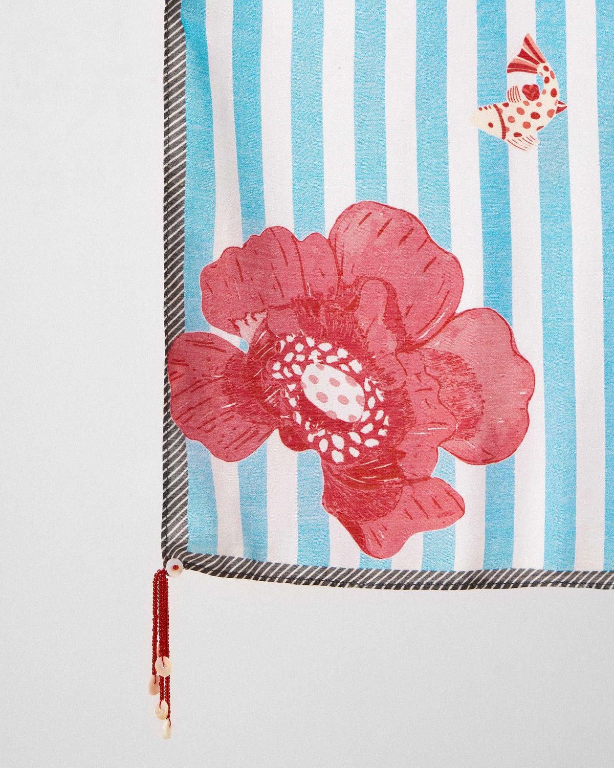 Close-up of the Fields Scarf's large red flower and beaded tassel.