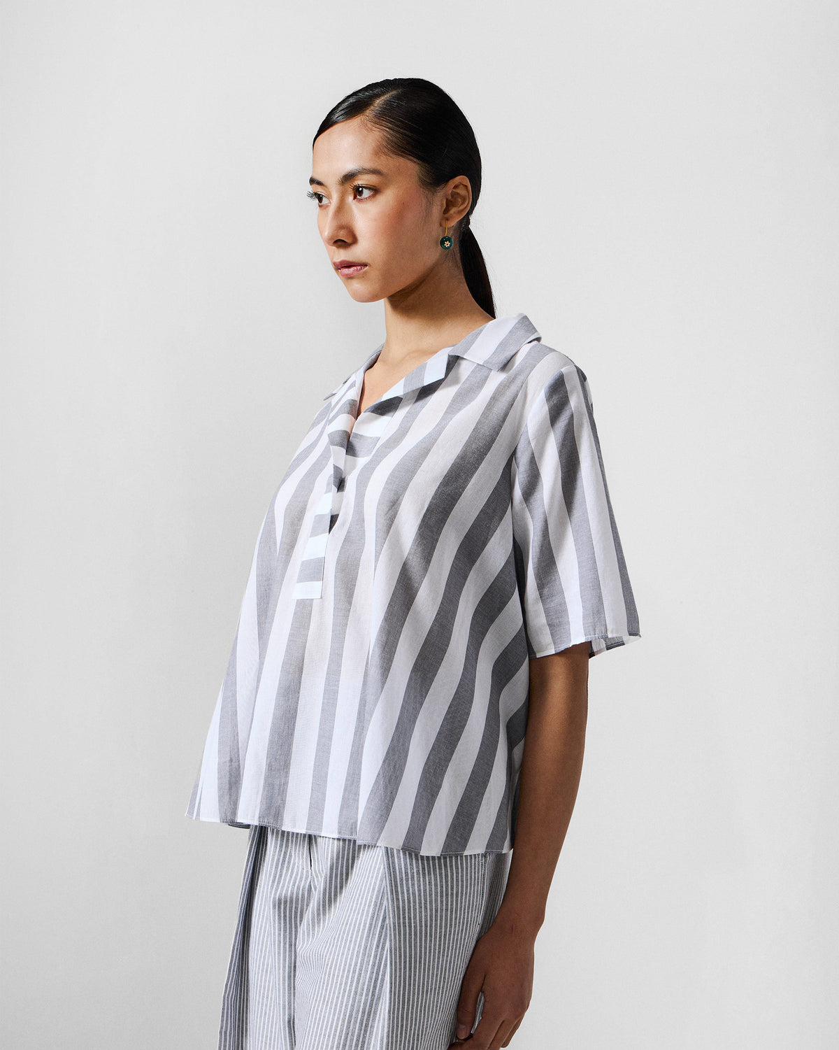 Side view of a grey and white striped Rann shirt.