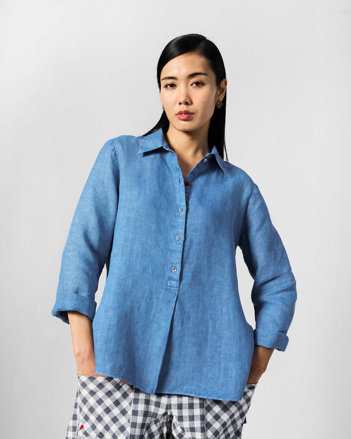 Person wearing a blue Mati shirt with rolled sleeves.
