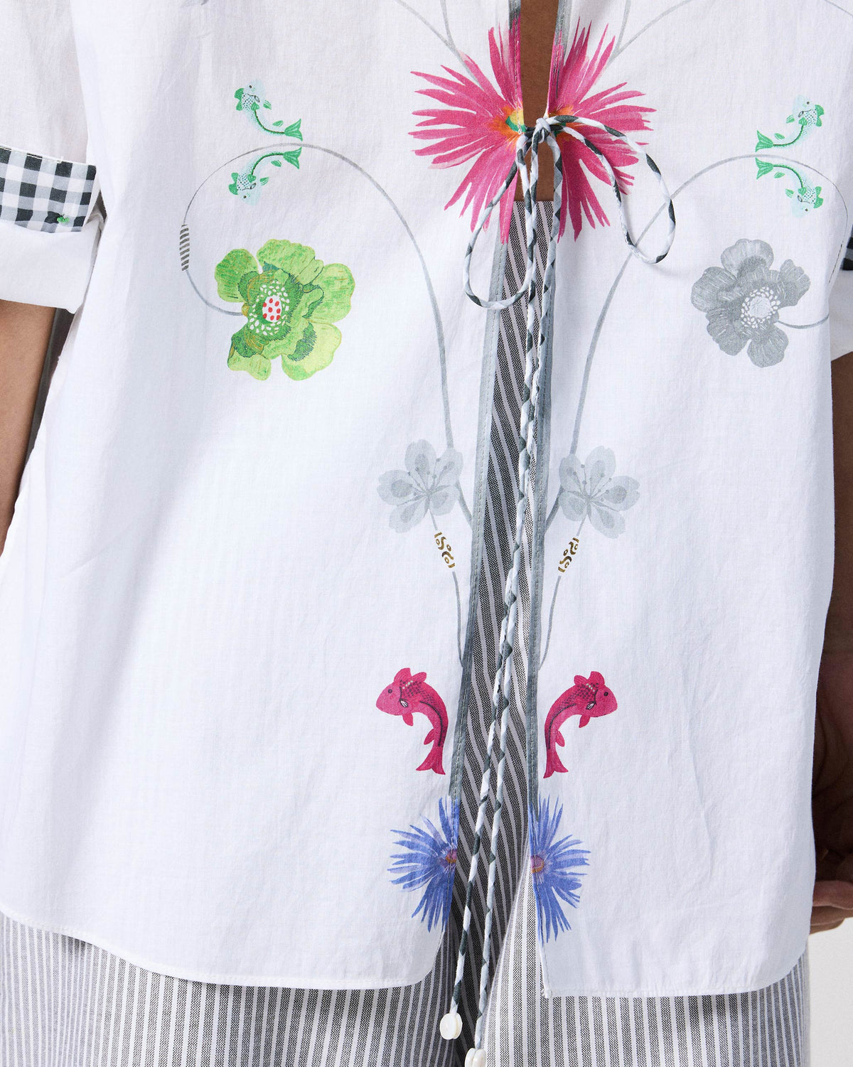 Close-up of floral and fish print with ties on a white Siv shirt.
