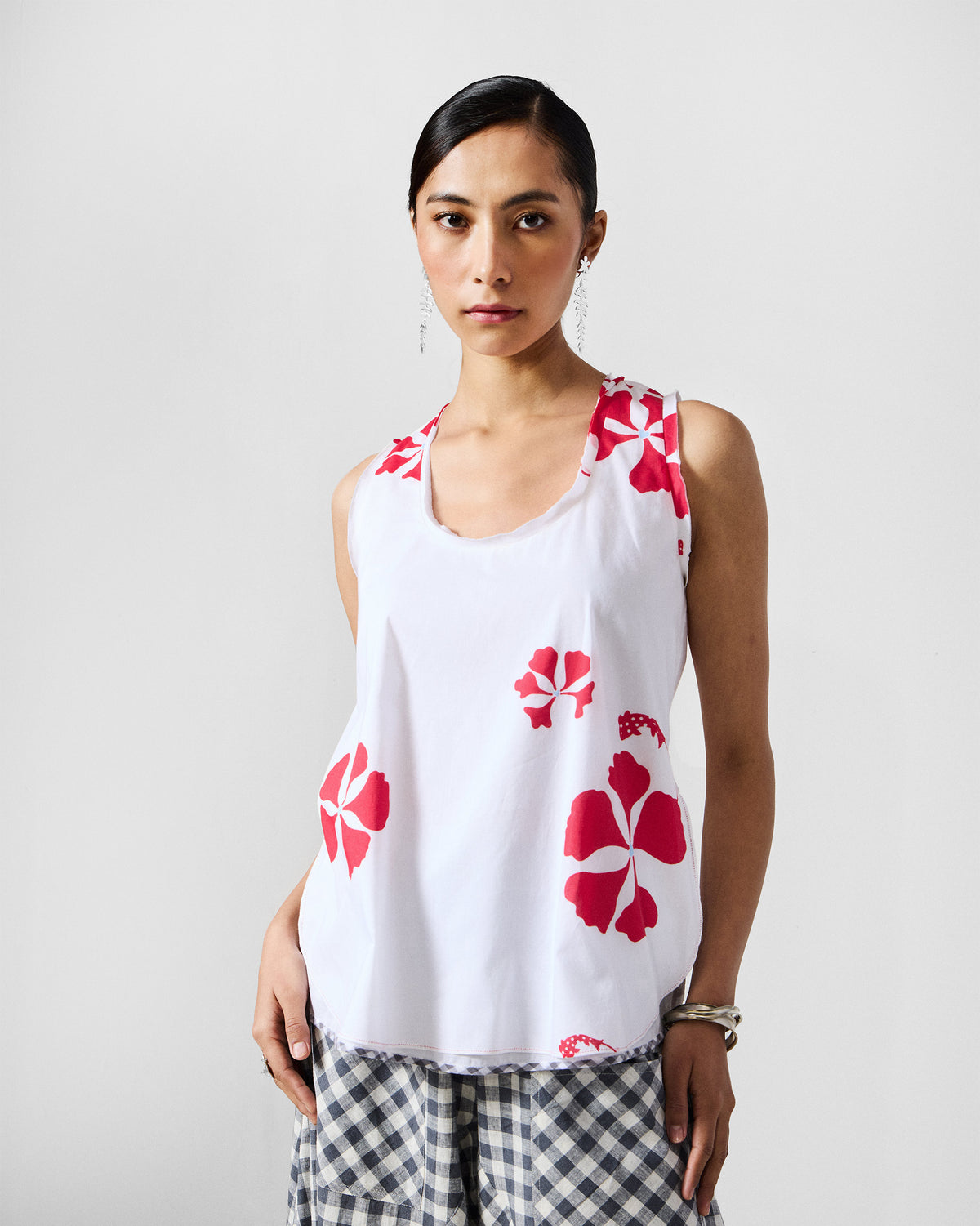 Front of a white Kiva top with red hibiscus print and a scoop neck.