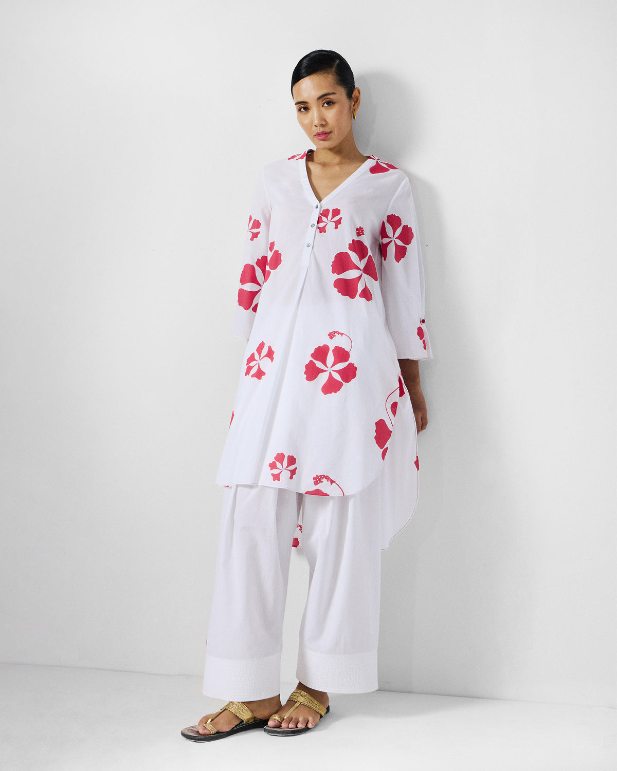 Person wearing a white and red printed Pampa kurta with a V-neck and floral print.