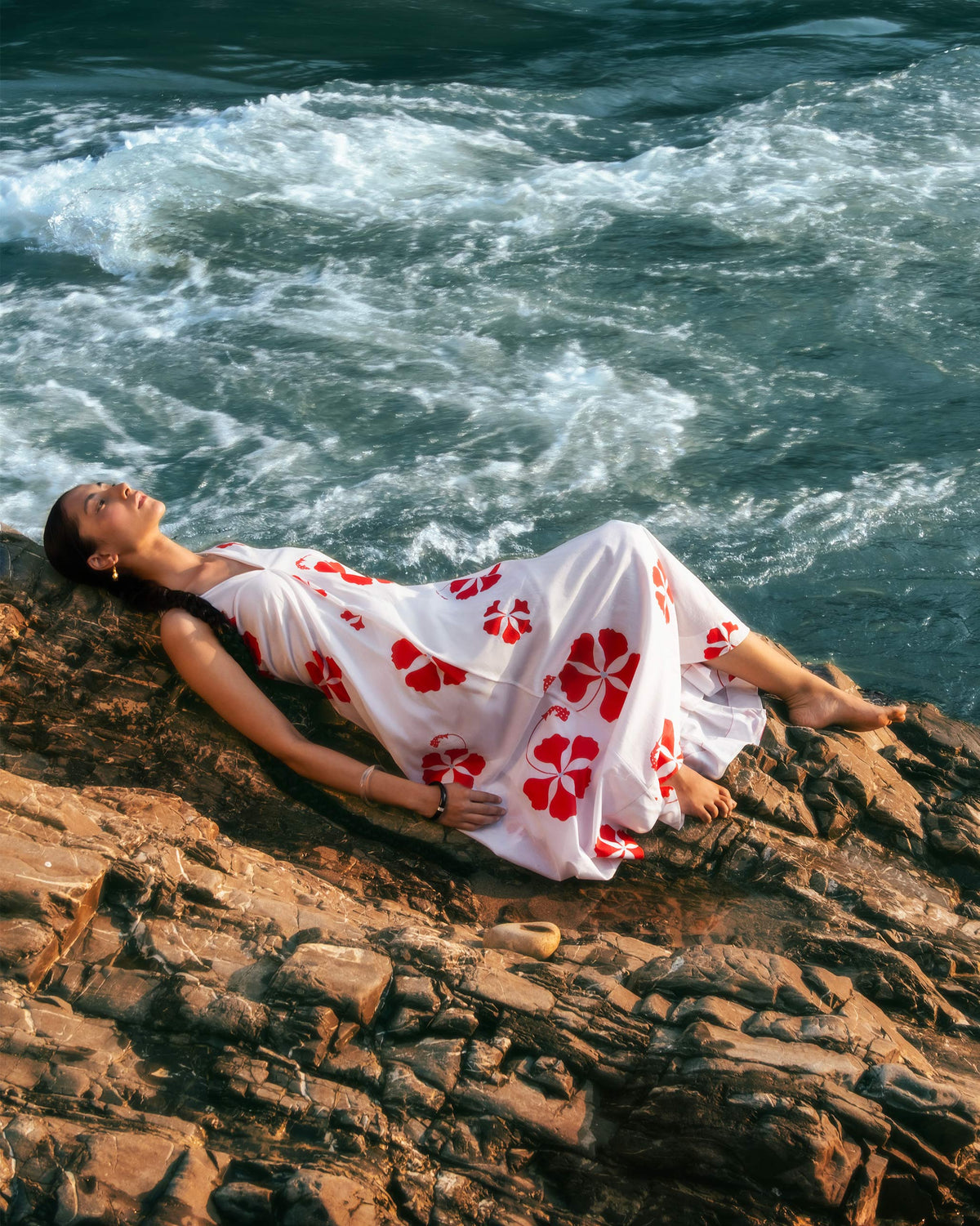 Person wearing a white Anya Dress with a red floral print outdoors.