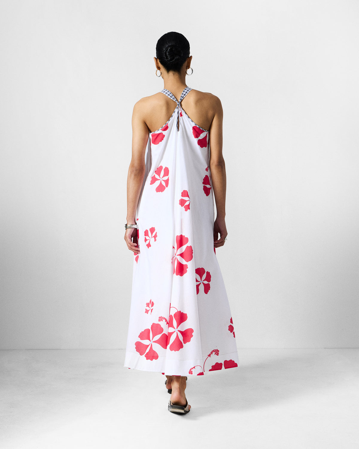 Back of a white Anya Dress with gingham straps and a red floral print.