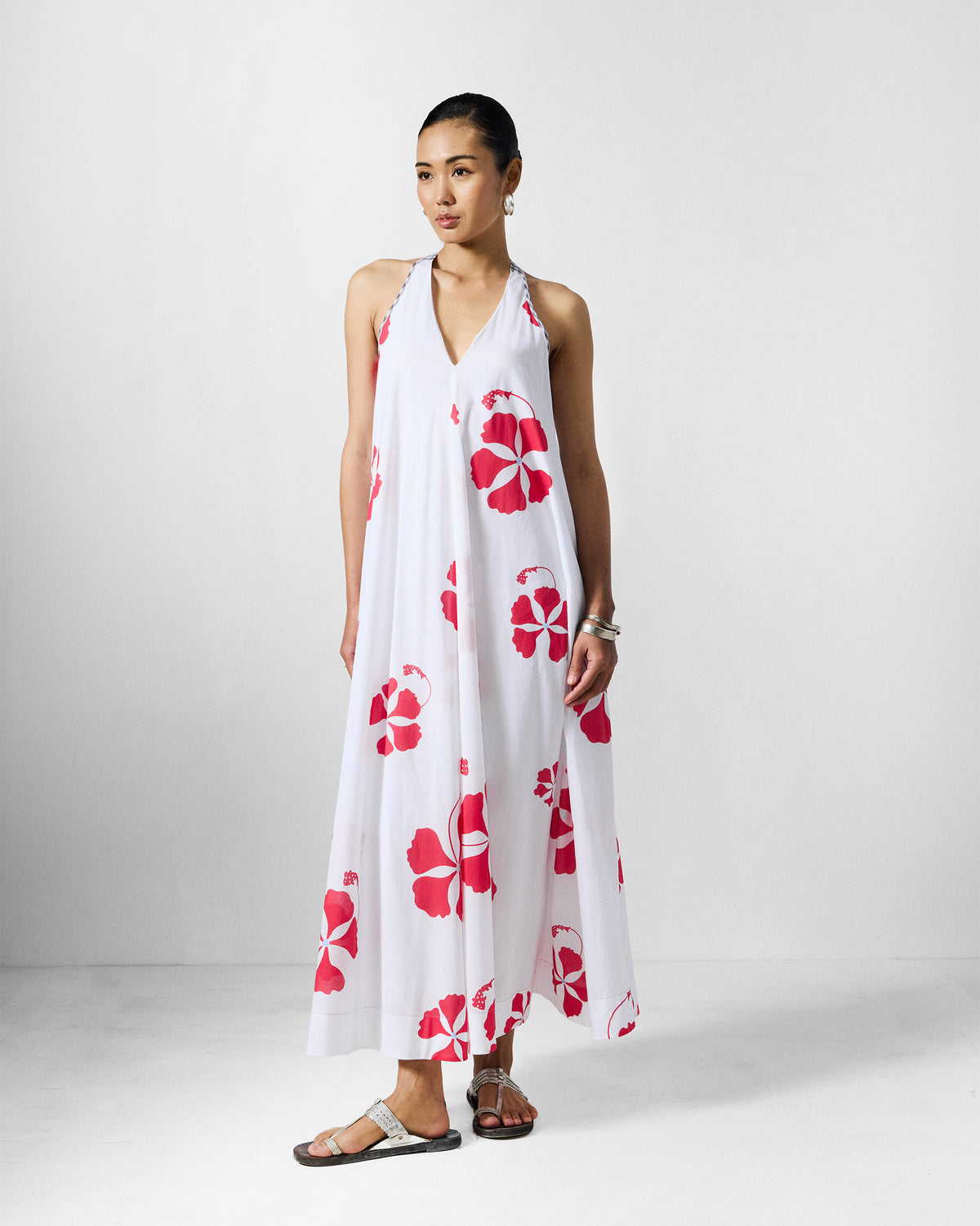Person wearing a white Anya Dress with scattered red flowers.