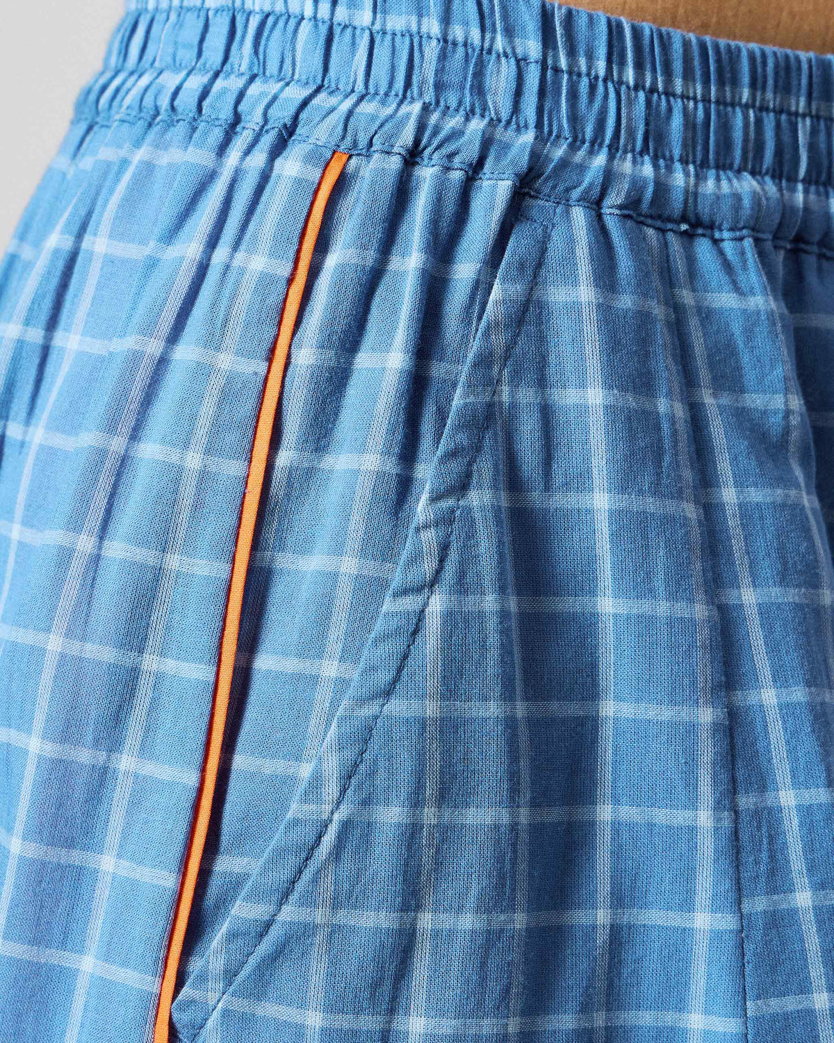 Close-up of riverside blue check Tia Pants showing the elastic waist and orange side trim.