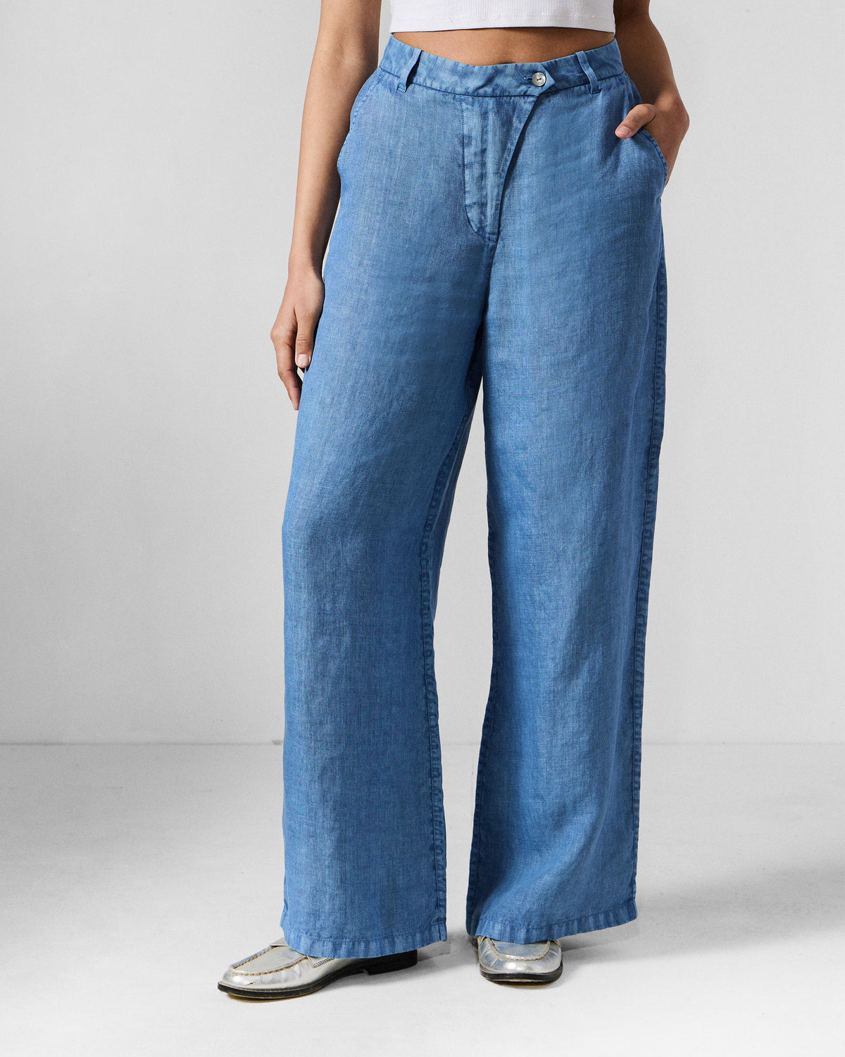 Person wearing blue wide-leg Aven pants with a button waist.
