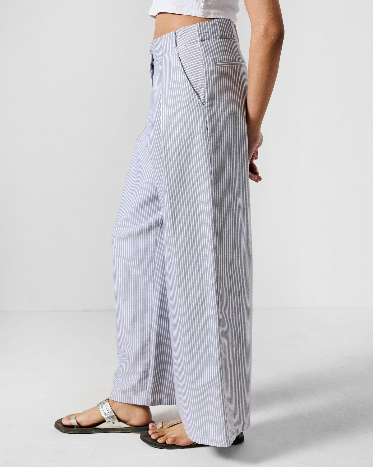 Side view of grey and white striped Costa pants with a side pocket.