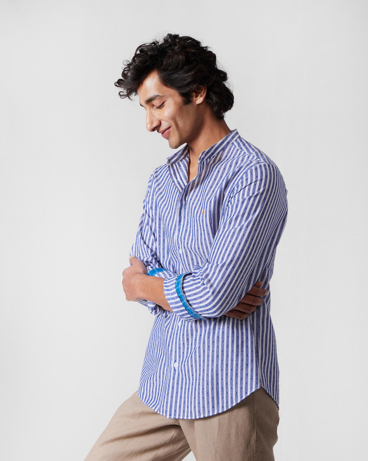Side view of a navy and white striped Nawab shirt with contrasting cuff lining.