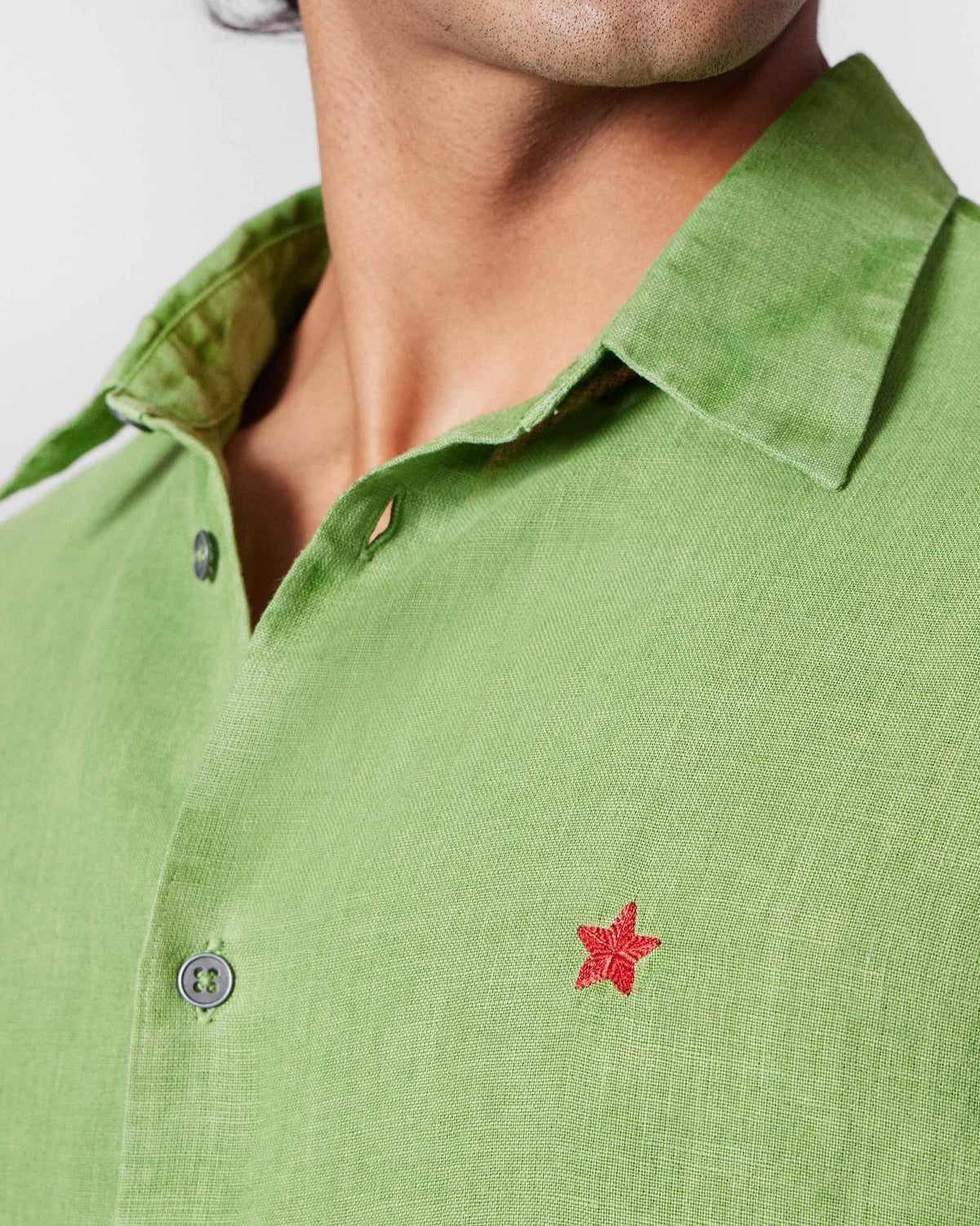 Close-up of the red star embroidery on a dark green Classic Shirt.
