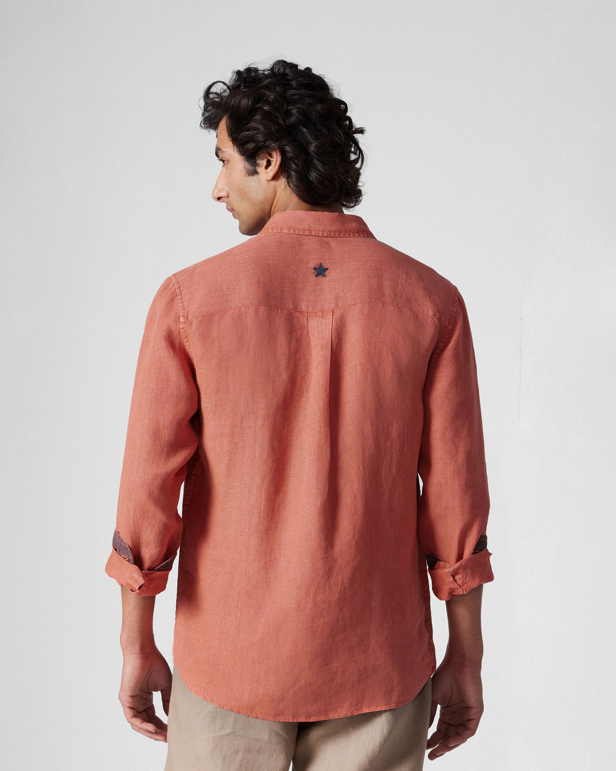 Back of a rust Indus Shirt with a navy embroidered star on the yoke.