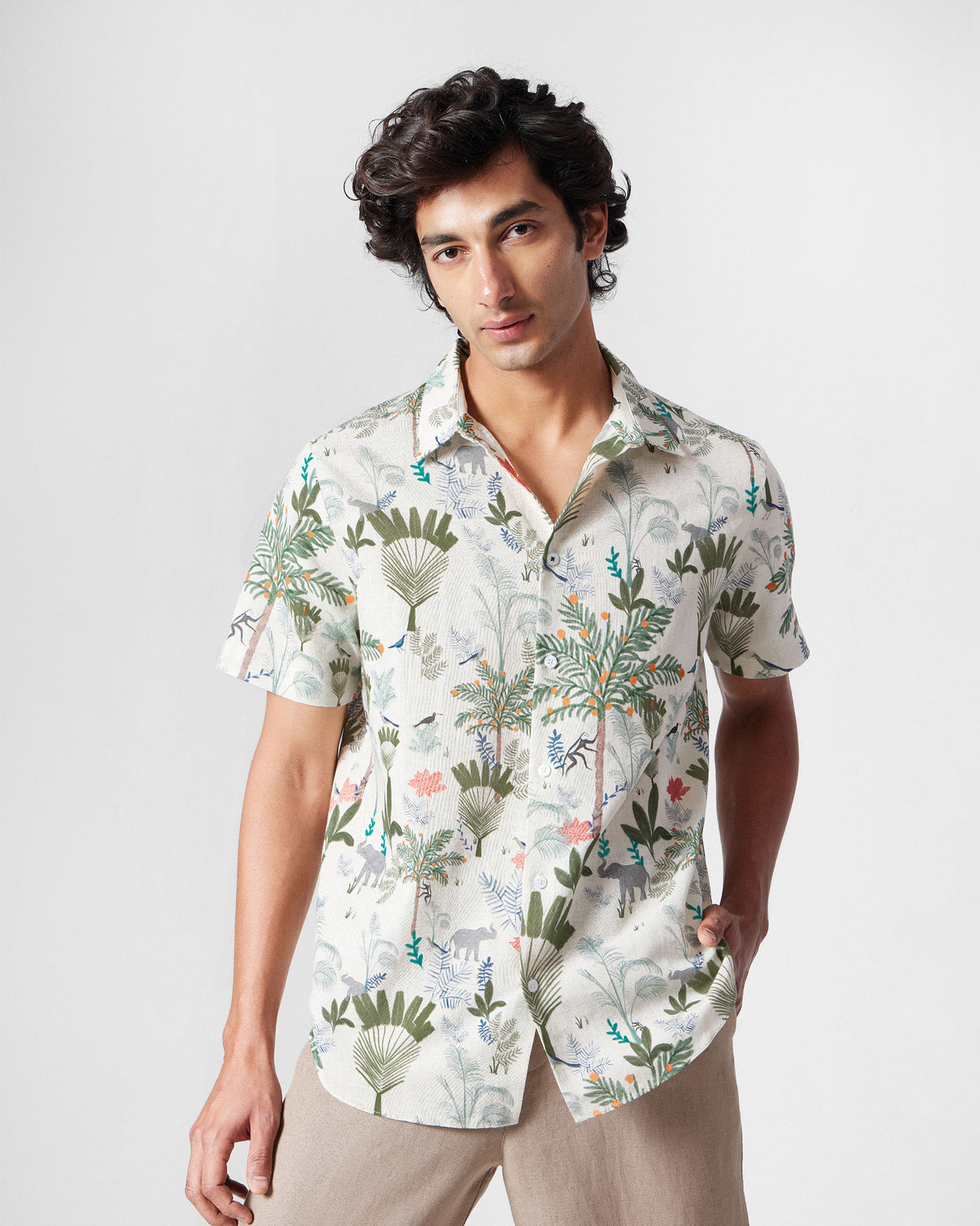 Person wearing a multicolour half-sleeve shirt with a monkey foliage print.