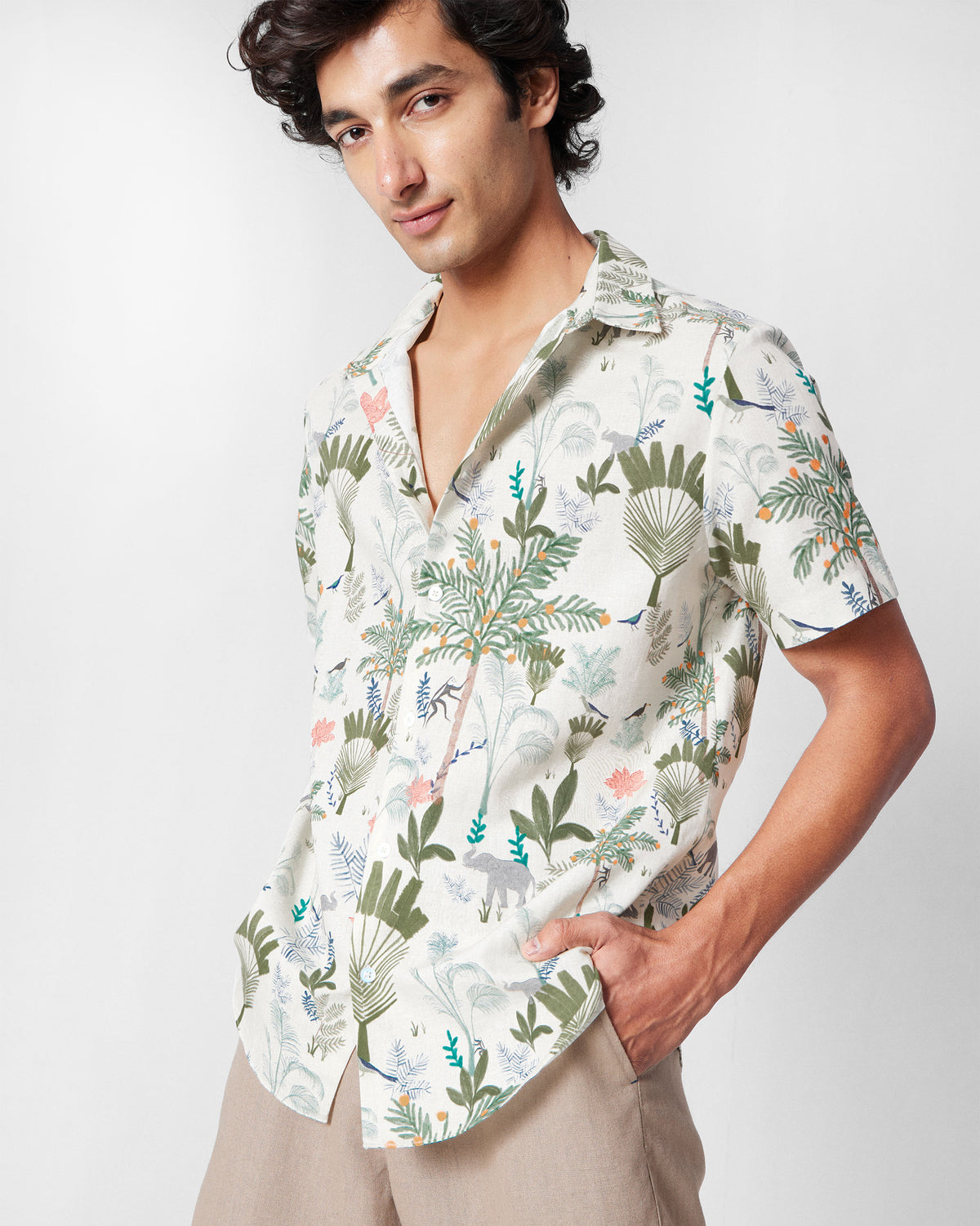 Person wearing a multicolour half-sleeve shirt with a tropical foliage print.