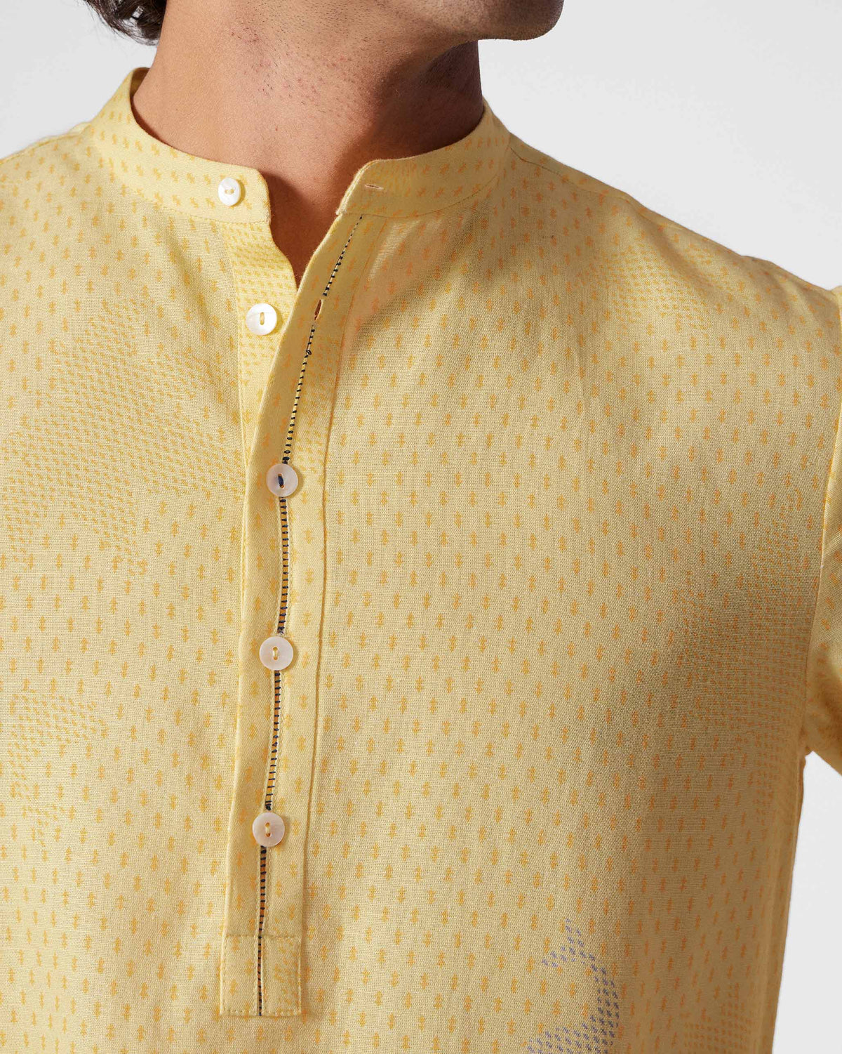 Close-up of a light yellow Astral kurta collar with tiny geometric print.