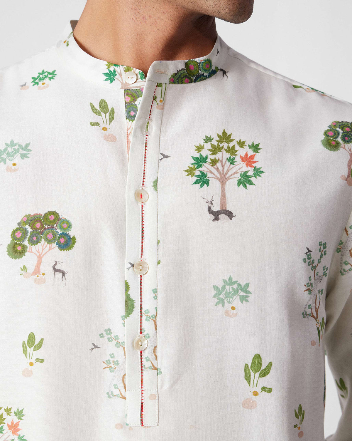 Close-up of ivory Astral kurta collar with green tree and deer print.