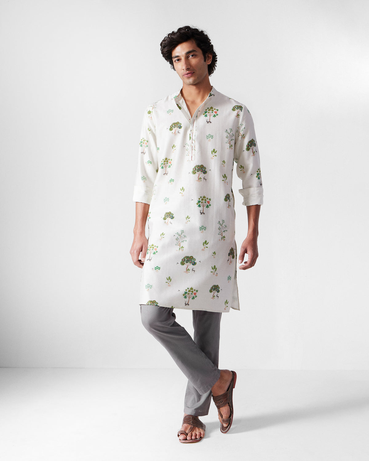 Person wearing an ivory Astral kurta with green tree valley print.