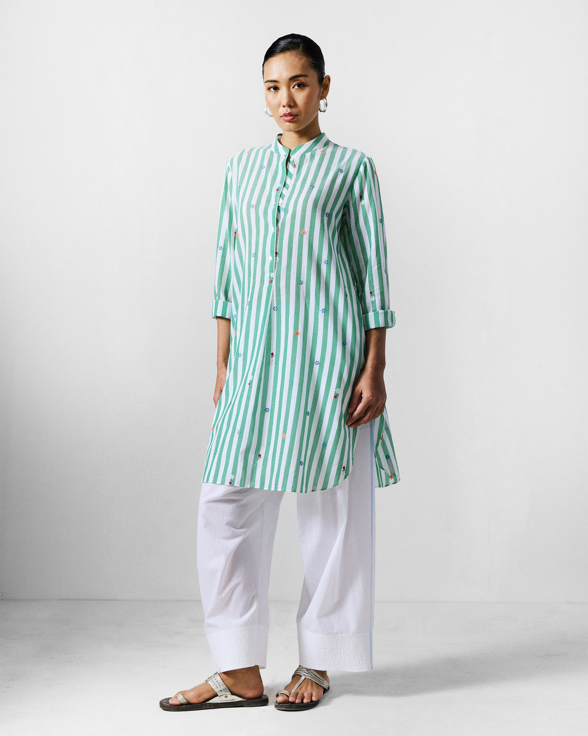 Person wearing a green and white striped mid-length kurta with floral embroidery.