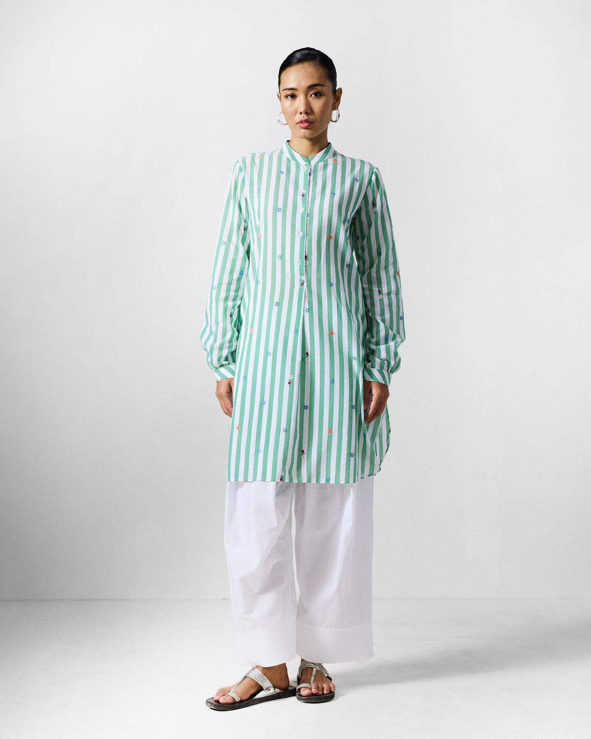 Person wearing a green and white striped embroidered mid-length kurta.