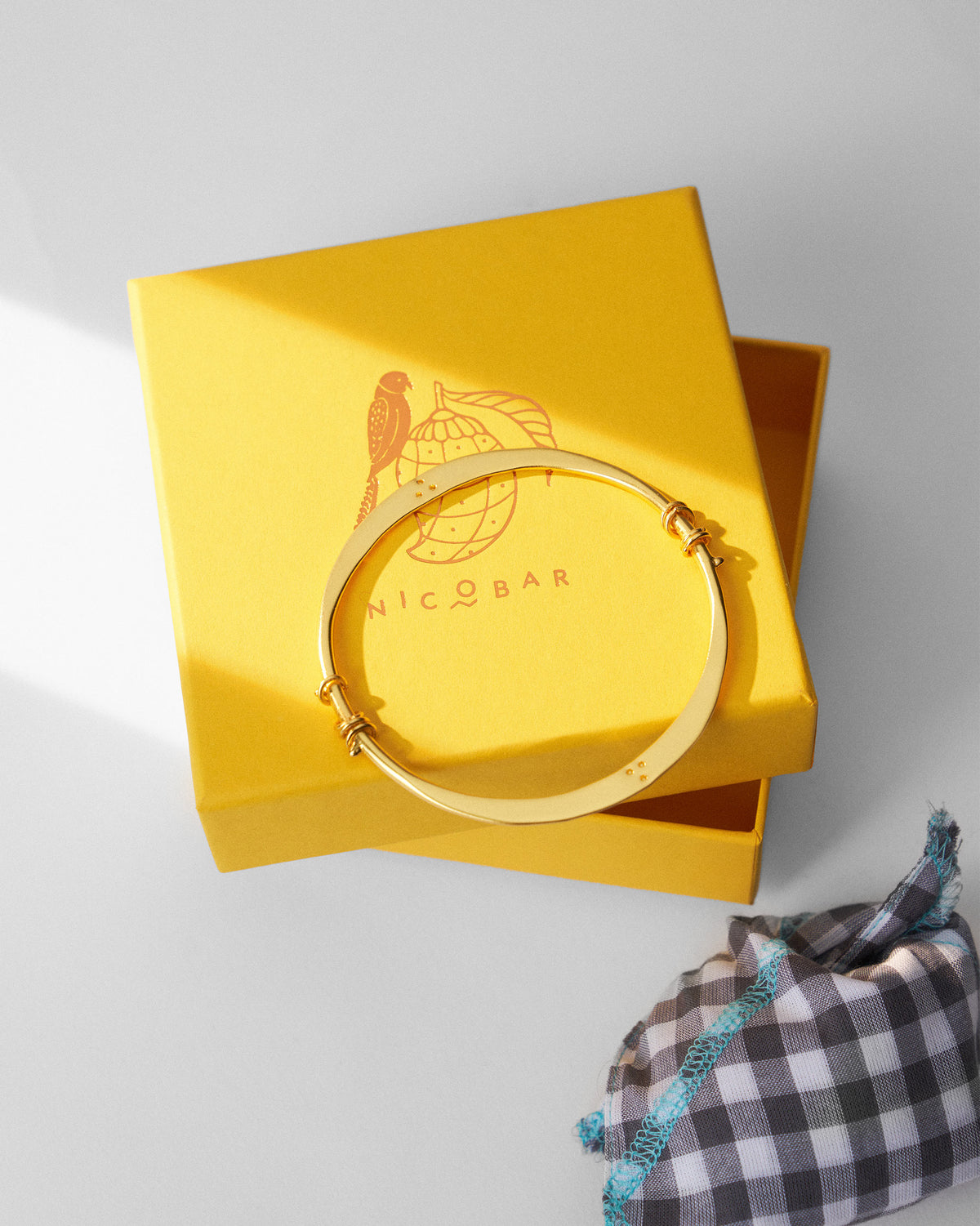 Gold qala bangle beside a Nicobar jewellery box.