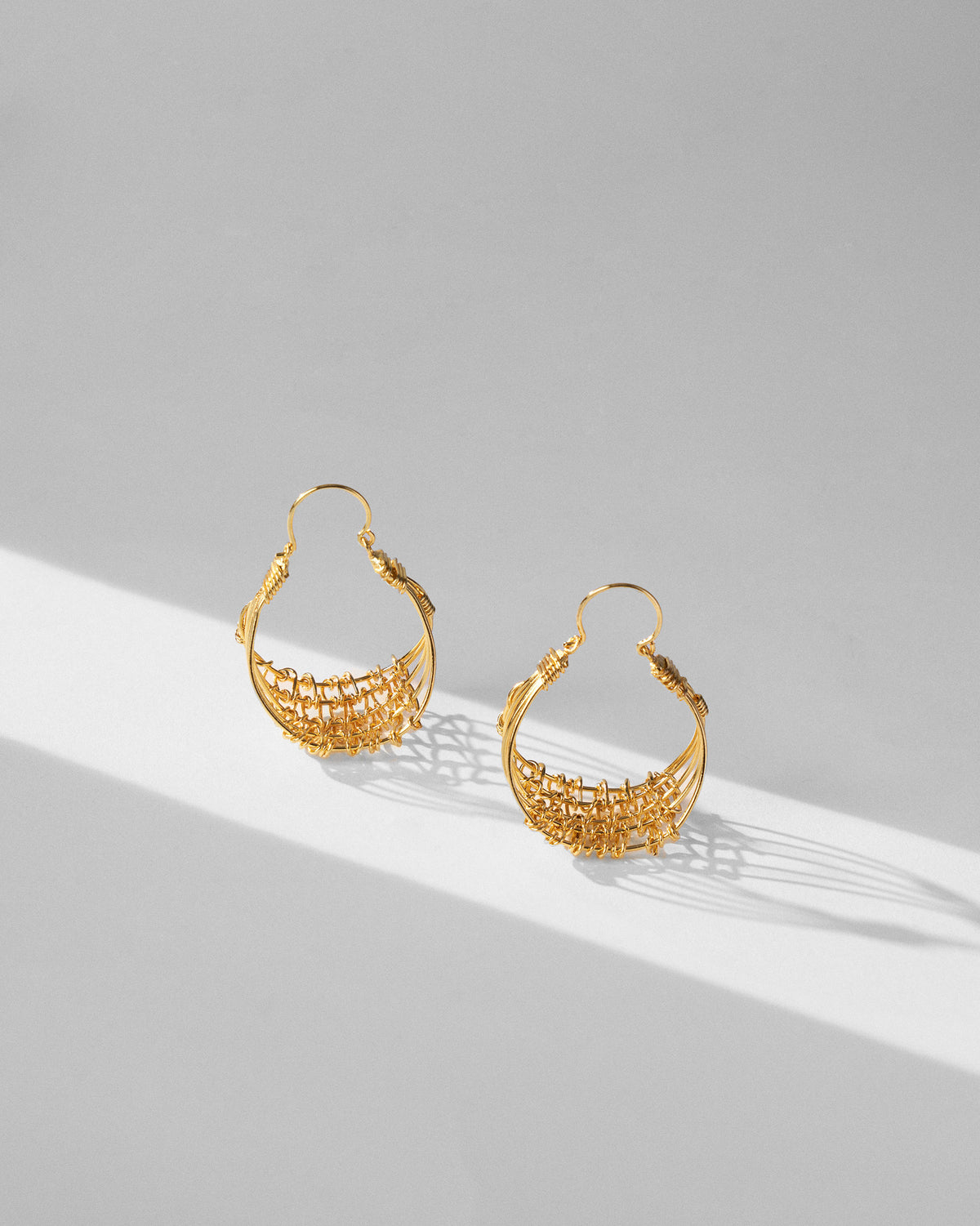 Pair of gold Shore balis with woven wire mesh bases.