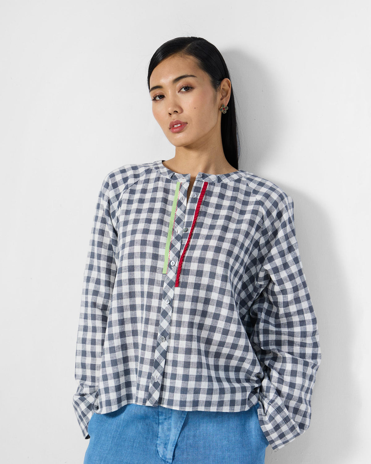 Person wearing a charcoal and white checked Zil top with red and lime placket trim.