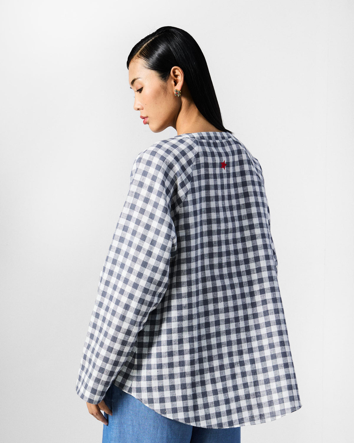 Back of a charcoal and white checked Zil top with a red star at the neck.