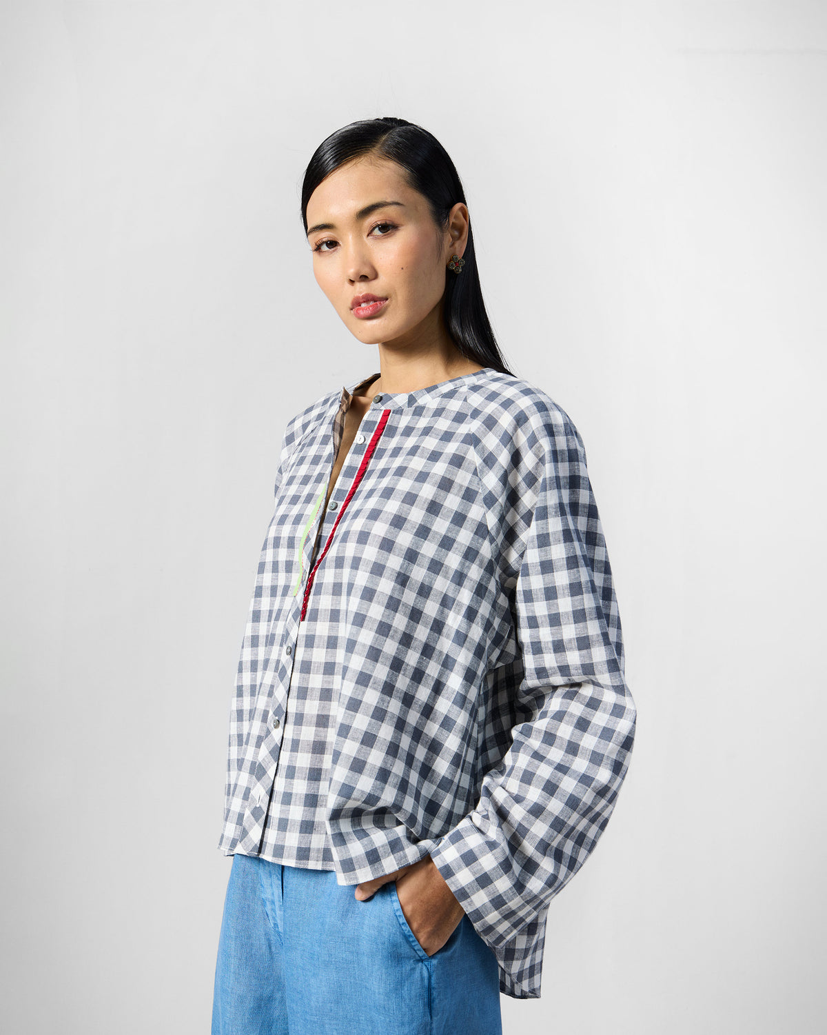 Person wearing a charcoal and white checked Zil top with red placket trim.