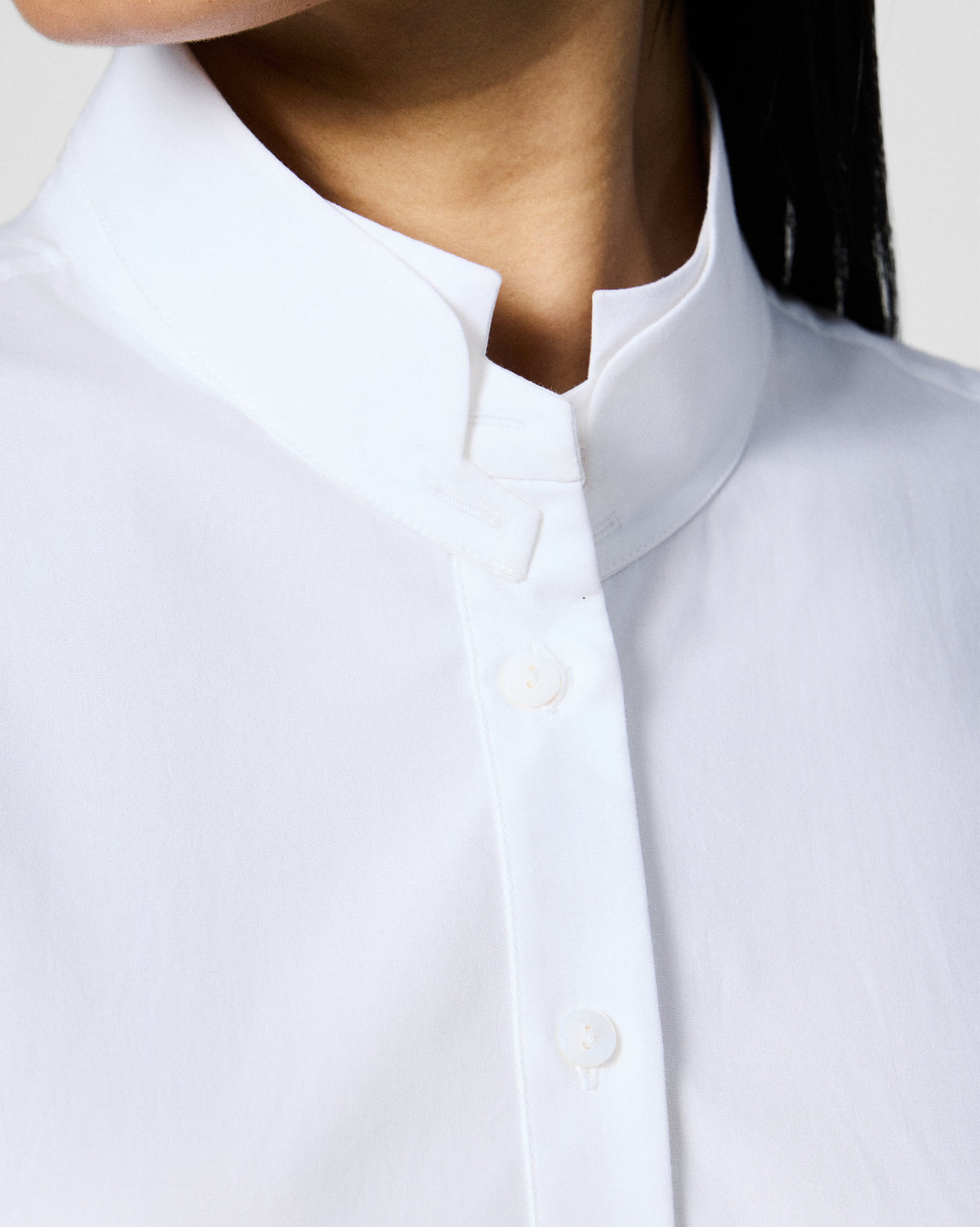 Close-up of a white Rai top mandarin collar and buttons.