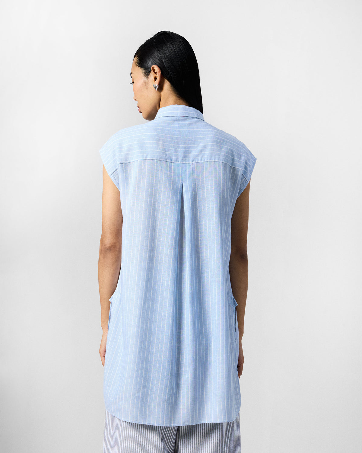 Back of a blue and white striped Vaah top with a central box pleat.
