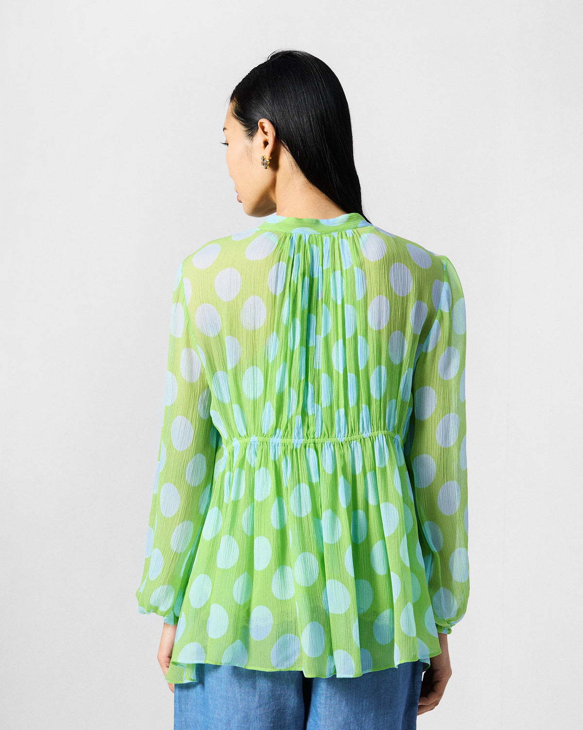 Back of a green polka-dot Jora top with gathered empire shaping.