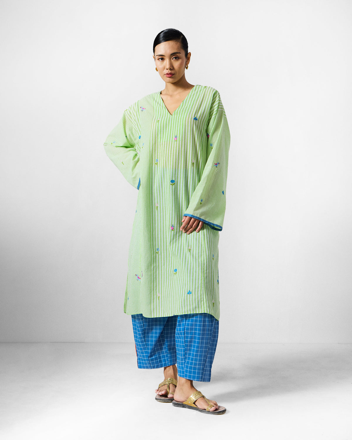 Person wearing a long green and white embroidered Gigi Kurta.